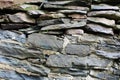 Rock wall made of both stacked and mortared irregular grey stones Royalty Free Stock Photo