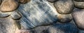 Rock wall made of colorful river rock, sun dappled, as an abstract textured background