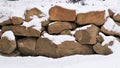 A rock wall with new fallen snow on the rocks.