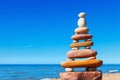 Rock zen pyramid of colorful pebbles on a beach on the background of the sea. Concept of balance, harmony and meditation