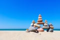 Rock zen pyramid of colorful pebbles on a sandy beach on the background of the sea. Concept of balance, harmony and meditation. Royalty Free Stock Photo