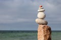 Rock zen pyramid of white pebbles on the background of the sea. Concept of balance, harmony and meditation Royalty Free Stock Photo