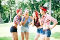 Group of friends at park having fun party. Cheerful girls with a cakes in hands. Retro style. Royalty Free Stock Photo