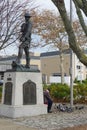 Rockaway Park, Queens, New York: An old man feeds pigeons beneath a statue