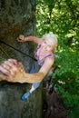 Rockclimber helping to female climber to reach top of mountain Royalty Free Stock Photo