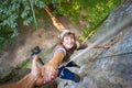 Rockclimber helping to female climber to reach top of mountain Royalty Free Stock Photo