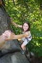 Rockclimber helping to female climber to reach top of mountain Royalty Free Stock Photo