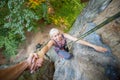 Rockclimber helping to female climber to reach top of mountain Royalty Free Stock Photo