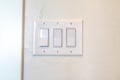 Rocker light switch with multiple flat broad lever mounted on the interior wall