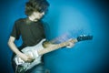 Rocker playing guitar on blue Royalty Free Stock Photo