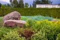 Rockery with 2 big natural stones among green plants.