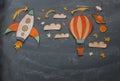 Rocket and air balloon cut from paper and painted over class room blackboard background.