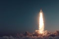 A rocket ascends towards the sky, propelled by powerful flames, rising through a layer of clouds during an early evening launch Royalty Free Stock Photo