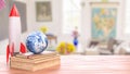 Rocket and Earth Globe on Books in Bright Classroom Setting 3d render Royalty Free Stock Photo
