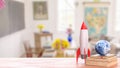 Rocket and Earth Globe on Books in Bright Classroom Setting 3d render Royalty Free Stock Photo