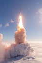 Rocket launch with bright exhaust plume ascending into a clear blue sky above a cloud layer. Royalty Free Stock Photo