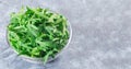 Rocket salad or arugula leaves in glass bowl, horizontal, copy space