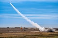 Rocket soaring in the sky, with a billowing cloud of smoke trailing behind it