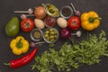 Rocket and spinach, eggs and tomatoes, yellow and red peppers, garlic, olives on a black background Royalty Free Stock Photo