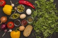 Rocket and spinach, eggs and tomatoes, yellow and red peppers, garlic, olives on a black background Royalty Free Stock Photo