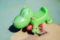 Rocking chair on a green metal spring made of plastic in the shape of a hippo on a playground with a rubberized coating. Royalty Free Stock Photo