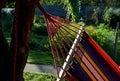 Rocking chair, hammock with wooden support among the trees in the garden. view of naked hairy white legs of a rocking man, striped Royalty Free Stock Photo