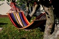 Rocking chair, hammock with wooden support among the trees in the garden. view of naked hairy white legs of a rocking man, striped Royalty Free Stock Photo