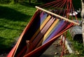 Rocking chair, hammock with wooden support among the trees in the garden. view of naked hairy white legs of a rocking man, striped Royalty Free Stock Photo