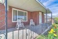 Rocking chairs on the front porch of a house with red brick wall and white door Royalty Free Stock Photo