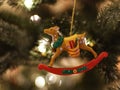 Rocking deer Christmas ornament hanging from tree.