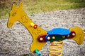 Rocking giraffe on spring on children playground in sand
