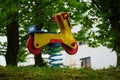 a rocking motorcycle on a spring, a stylized wooden toy in red and yellow for small children on a thick metal coiled spring stepp