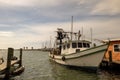 ROCKPORT, TX - 3 FEB 2020: White and green shrimp boat at a wooden dock