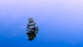 Rocks balanced on each other in blue tranquil water Royalty Free Stock Photo