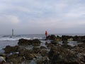 the rocks on the beach as breakwaters and there someone on the other end