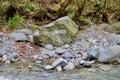 Rocks and a boulder by a stream Royalty Free Stock Photo