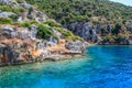 Rocks and bright turquoise water in the Mediterranean Sea. Ruins of an ancient city in Bodrum