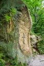 Rocks with a broken-down cross them at the gates of the monastery in the cave in the Carpathian foothills Rozhirche