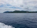 Rocks cliff mast green tress rain forest island ocean sea water blue ferry boat transport gulf thailand koh samui tao Royalty Free Stock Photo