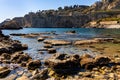 Rocks and cliffs of Capo Taormina cape on Ionian sea shore aside Giardini Naxos town in Messina region of Sicily in Italy Royalty Free Stock Photo