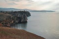 Rocks cliffs stand on shore of lake baikal, sunset