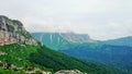 Rocks in clouds and green valleys below