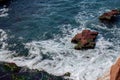 Rocks covered in sea weed during low tide. Pacific ocean views. White sea foam and cliffs Royalty Free Stock Photo