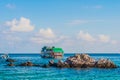 Rocks and fishing boats floating on blue sea