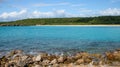 Rocks in front of a sea with turquoise water and a sandy beach Royalty Free Stock Photo