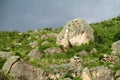 Rocks on a green hill at sunset before rain Royalty Free Stock Photo