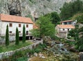 Rocks, houses and Duman, the spring of the Bistrica River in the small town of Livno in Bosnia and Herzegovina Royalty Free Stock Photo