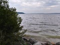 Rocks Lake trees pebbles waves water sky clouds vegetation beach evening view scenic