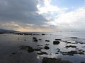 Rocks landscape sea with giants cumulonimbus clouds in the sky and cargo ships at the horizon . Livorno, Tuscany, Italy Royalty Free Stock Photo