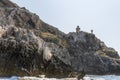 Rocks and the lighthouse in the background of the island of San Domino